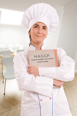 immagine di un addetto che manipola alimenti con il manuale haccp in mano